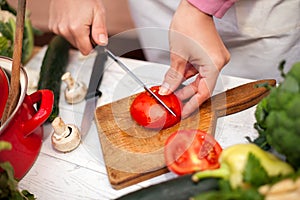 Woman cutting tomato on chopping board