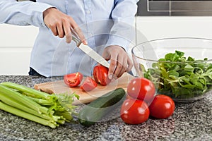 Woman cutting tomato