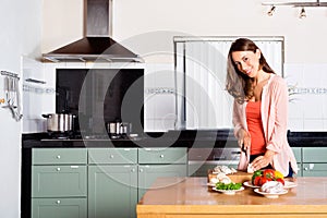 Woman Cutting Vegetables At Kitchen Counter