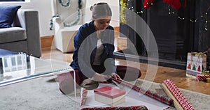 Woman cutting wrapping paper for Christmas presents at home