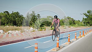 Woman cycling on bicycle lane outdoors. Female cyclist riding on bike path at sunny summer day. Athletic sportive woman pushing pe