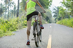 Woman cycling on morning tropical forest trail