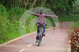 Woman cyclist fun riding bike on forest trail