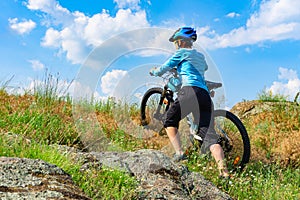 Woman cyclist pushing her bike up a steep slope