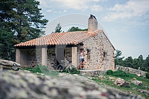 Woman cyclist putting on her helmet when leaving a mountain refuge