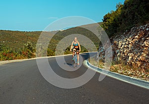 Woman cyclist riding a bike on a mountain road