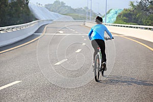 Woman Cyclist Riding Mountain Bike on city road