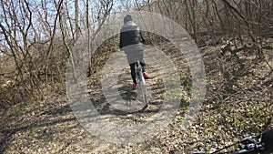 Woman cyclist riding mountain bike. Cycling along the forest road on sunny day. Adventure Lifestyle Concept.