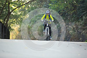 Woman cyclist riding mountain bike on forest trail