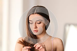 Woman with damaged hair on blurred background.