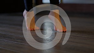 Woman dancer beautiful bare feet step on toes carefully on floor at ballet barre close view slow motion