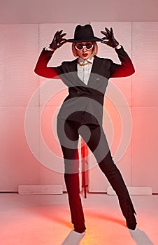 woman dancer in black suit dancing. Studio shot of young woman in business style