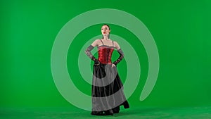 Woman dancer dancing on chroma key green screen. Female in flamenco style dress performs elegant spanish dance moves