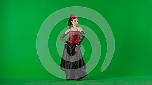 Woman dancer dancing on chroma key green screen. Female in flamenco style dress performs elegant spanish dance moves