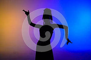 Woman dancer silhouette dancing on colorful background. Graceful dancer passionately dancing flamenco performing