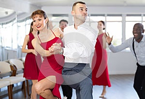 Woman dances incendiary boogie woogie with man partner during choreography lesson