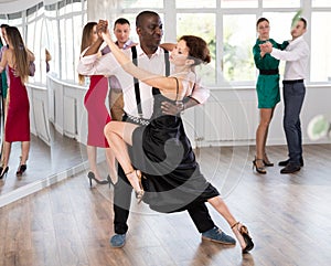 Woman dances incendiary tango with African man partner during choreography lesson