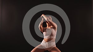 Woman dancing booty twerk sitting on the floor on a blue background