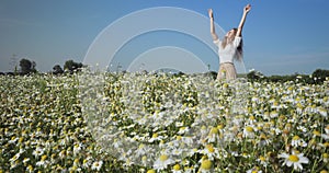 Woman dancing in a field of chamomiles