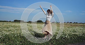 Woman dancing in a field of chamomiles