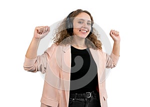 Woman dancing while listening music with a wireless headphones. White background