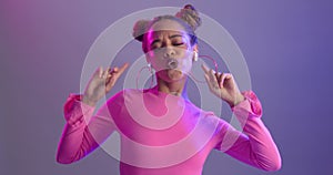 Woman, dancing and music with earphones in studio or streaming entertainment or neon light, playlist or listening