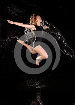 Woman dancing water jumping black background