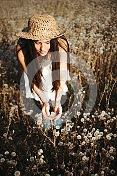 Woman on dandelion field in sunset. Allergic