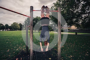 Woman dangling from pullup bars