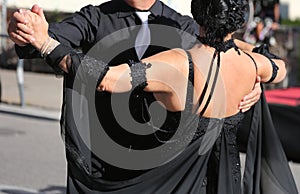 Woman with dark dress dancing with a man on the street