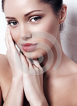 Woman with dark hair with natural makeup and radiance health skin posing