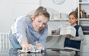 Woman with daughter cleaning house