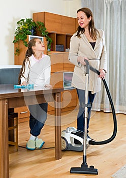 Woman and daughter cleans the house