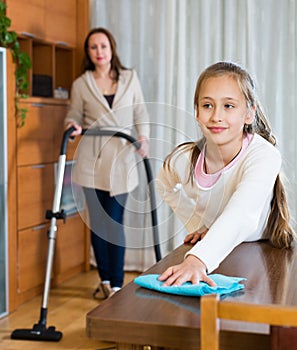 Woman and daughter cleans the house