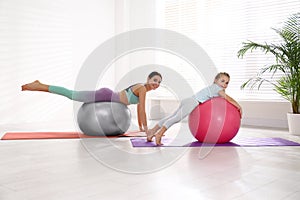 Woman and daughter doing exercise with fitness balls