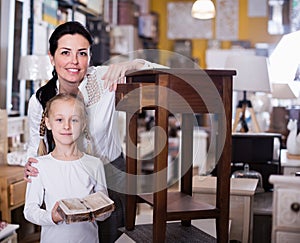 Woman with daughter standing with curbstone in store photo