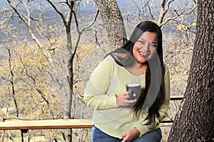 Woman at dawn in a cabin in the woods drinks coffee to activate the mind with caffeine because it is rich in antioxidants