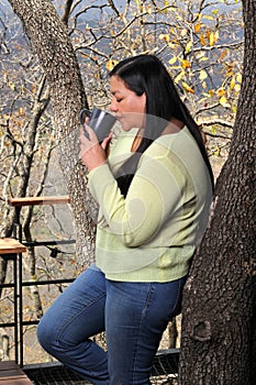 Woman at dawn in a cabin in the woods drinks coffee to activate the mind with caffeine because it is rich in antioxidants
