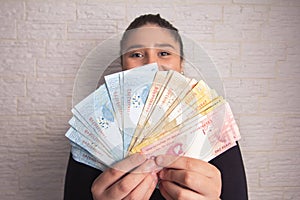 Woman is dealing with money from Brazil. Economy, salary, credit, payment, shopping, success concept