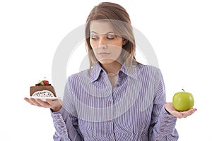 Woman debating cake or apple