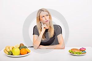 Woman deciding between healthy and unhealthy foods