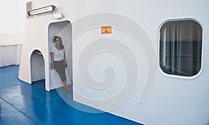 Woman on deck of ferry boat standing in doorway