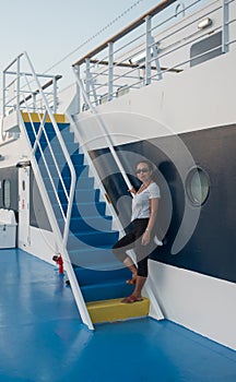 Woman on deck of ferry boat standing on stairs