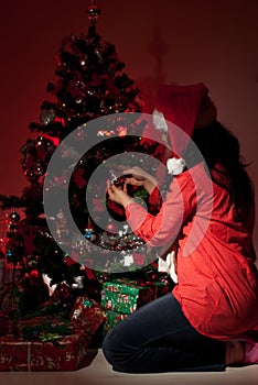 Woman decorate Christmas tree in night photo