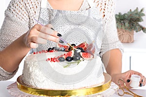 The woman decorates cake kanduriny