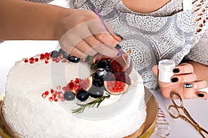 The woman decorates cake kanduriny