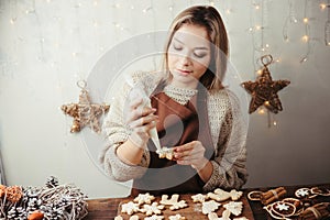 Woman decorating Christmas gingerbread cookies