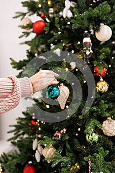 Woman is decorating Christmas tree