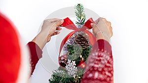 Woman decorating christmas tree with beautiful red bow. Xmas ornaments