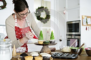 Woman decorating a cupcake hoilday